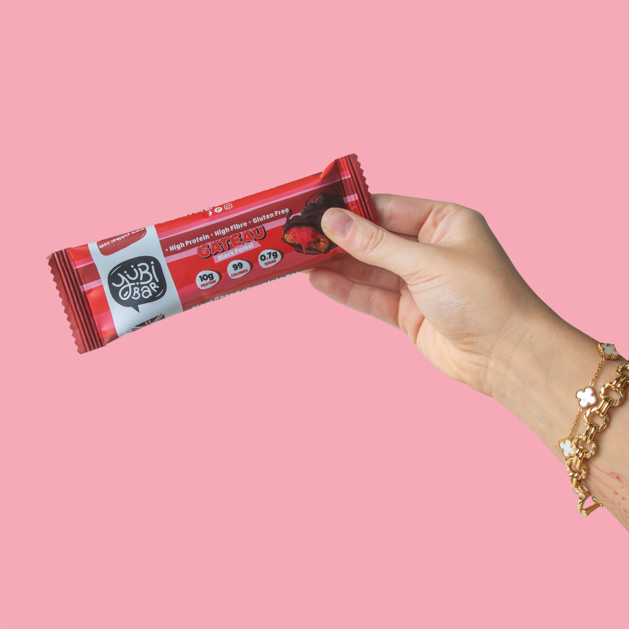 Hand holding Yubibar Black Forest Gateau 99 calorie protein bar