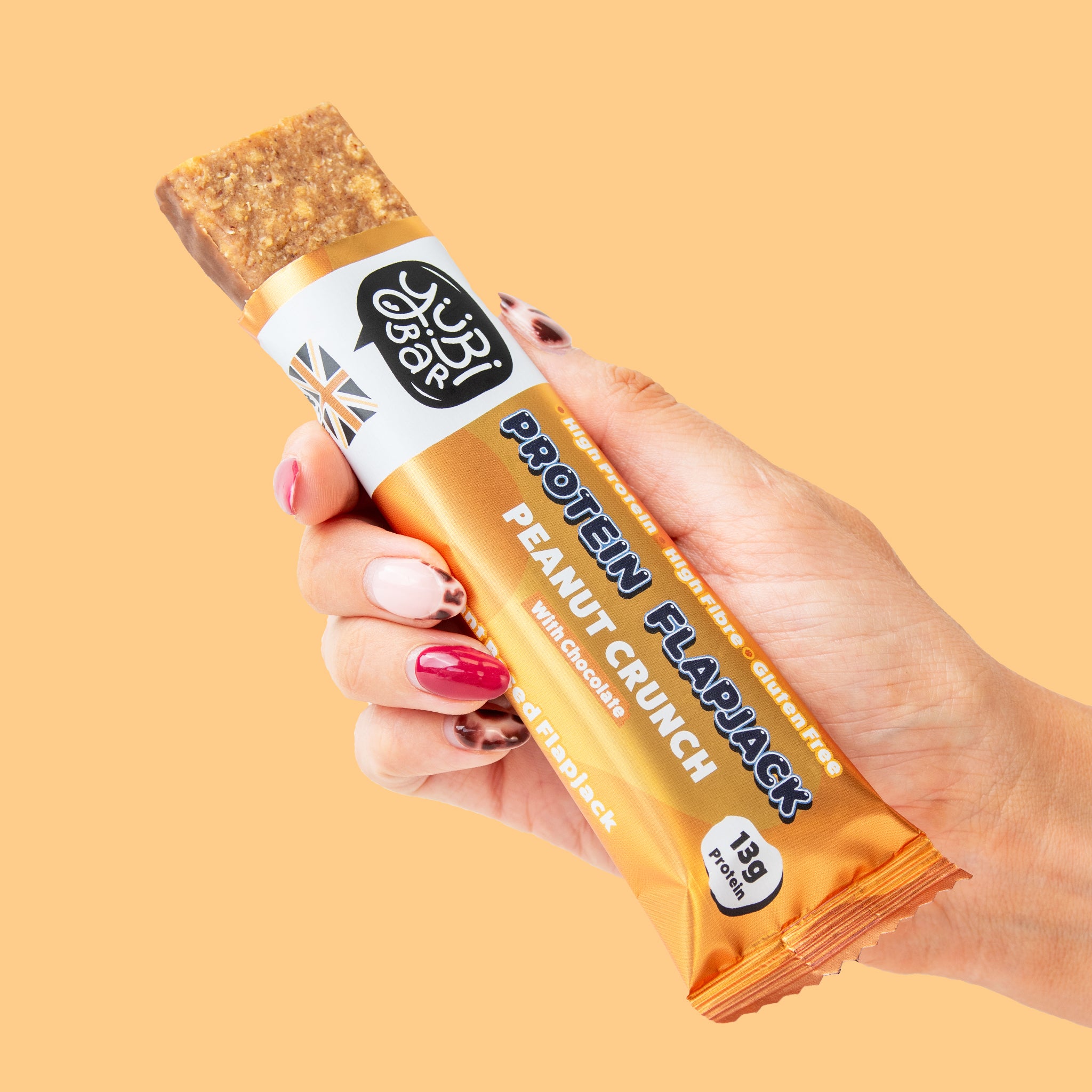 hand holding a low sugar, high protein, high fibre, gluten free and plant based high protein Peanut Flapjack